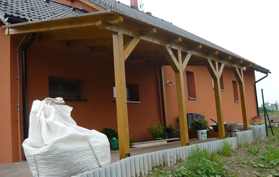 Dřevěný přístřešek s pultovou střechou u rodinného domu